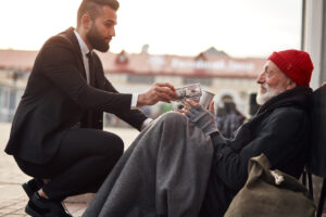 man giving homeless man money deposit photo December 2021
