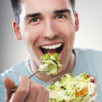 man taking a bite of salad deposit photo 12 30 21