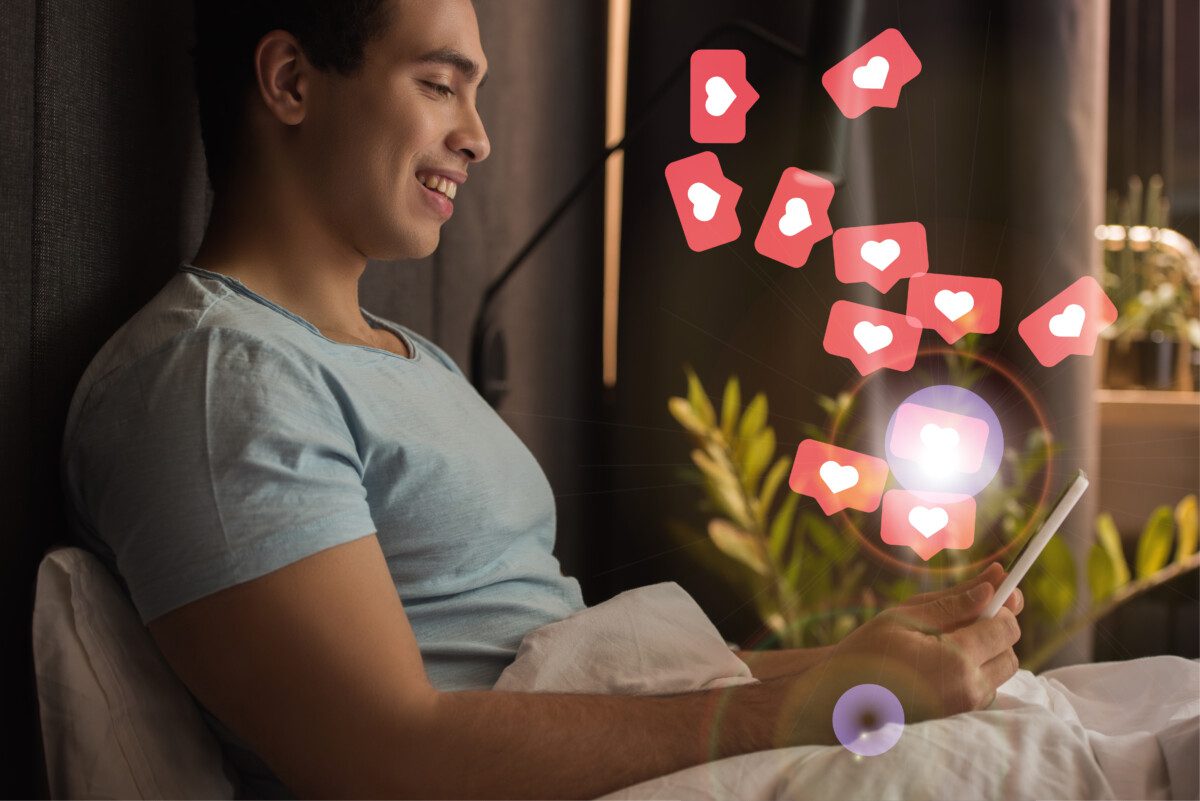man with phone in bed and heart emojis deposit photo december 2021