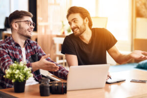two men smiling over laptop deposit photo January 2022