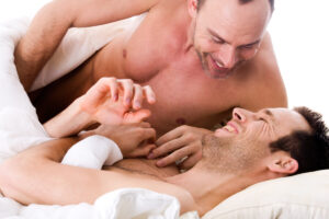 smiling gay male couple in bed deposit photo April 2021 1