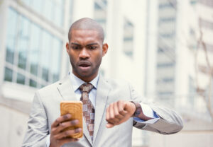 black man in suit looking at cell phone and watch deposit photo 9 28 22