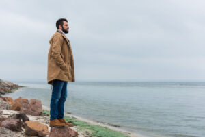 lonely man in peacoat on beach looking out deposit photo 11 6 22