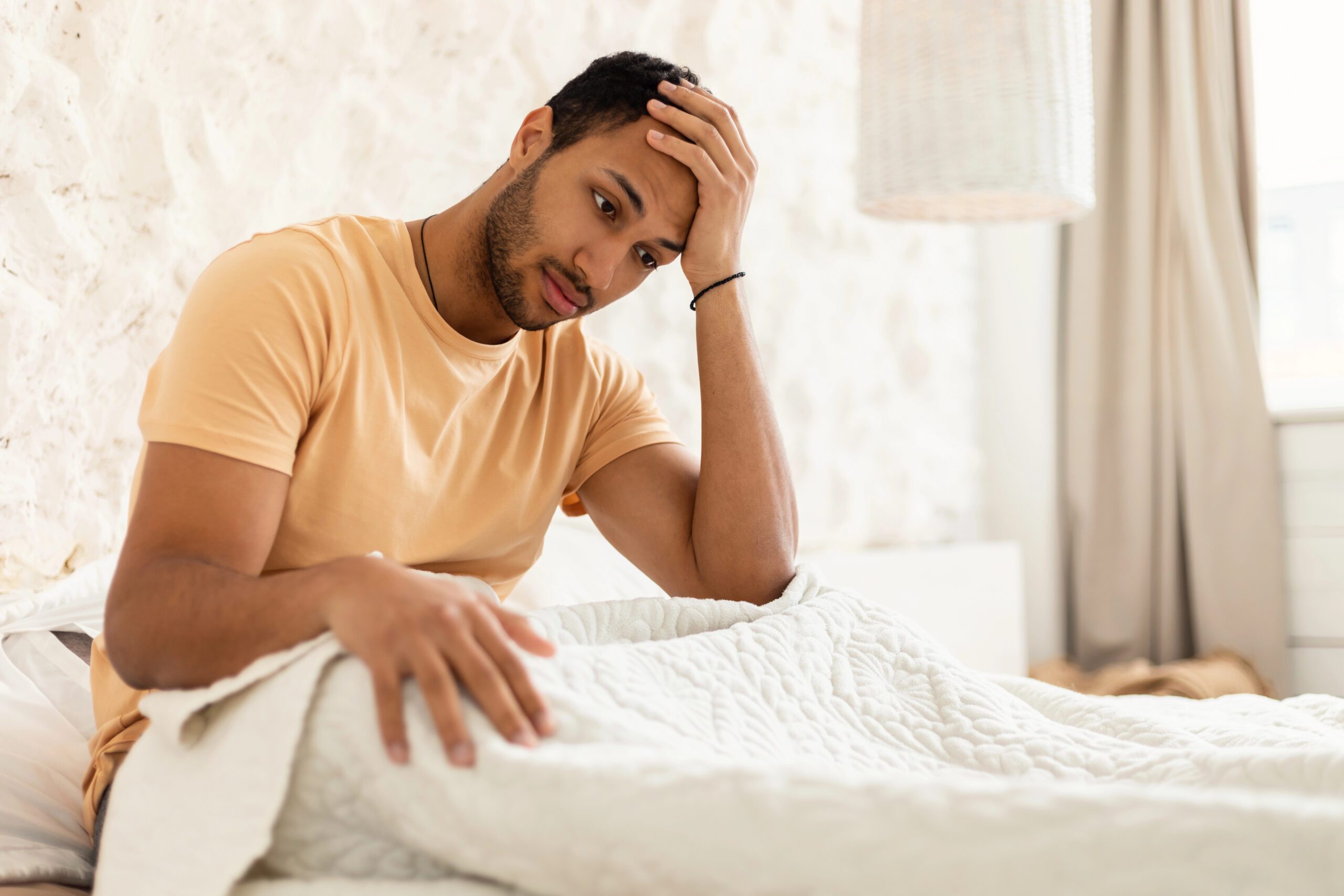 Gay man sitting alone after a breakup in quiet reflection