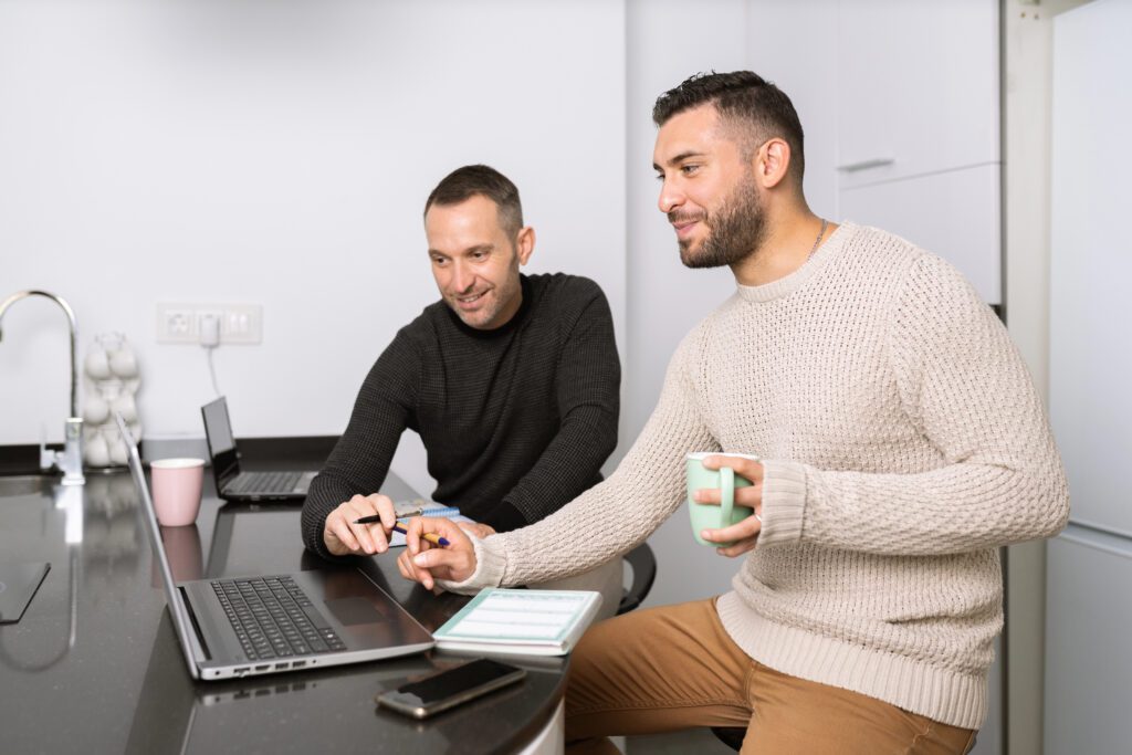 Gay couple working together at home with their laptops.