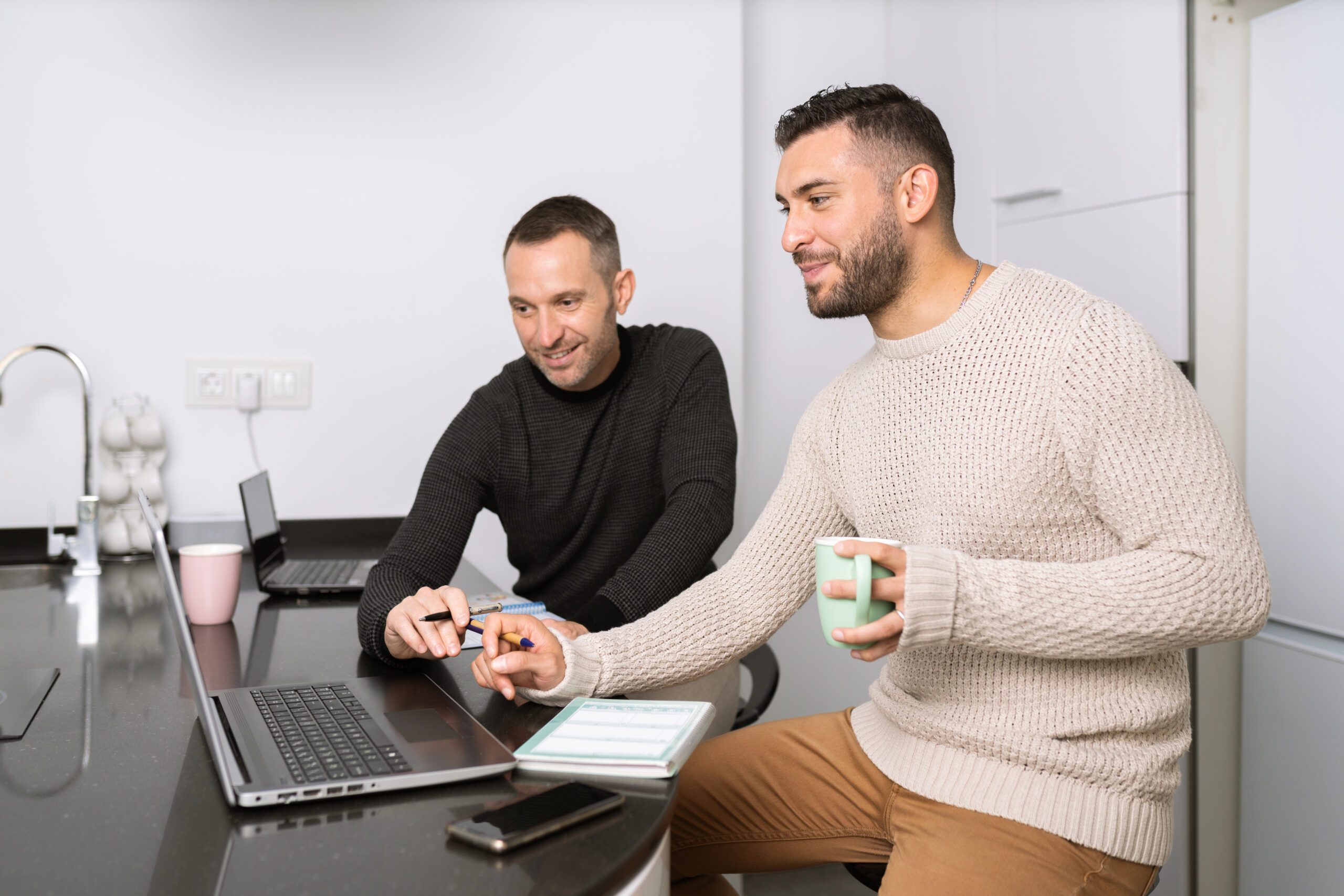 Gay couple working together at home with their laptops.