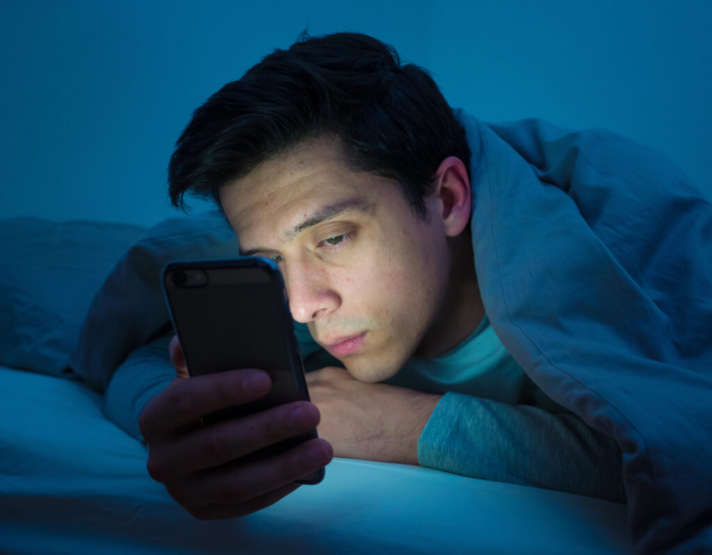 gay man man alone looking at phone at night
