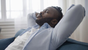 Successful gay man relaxing at home after work, representing the transition from achievement to emotional authenticity.