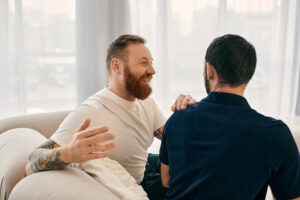 Gay couple talking openly together on a couch at home