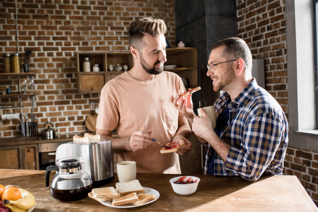 Two men in a relationship having breakfast together at home