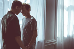 Two men expressing intimacy through affectionate touch
