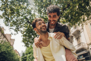 Two young men talking and laughing in the garden. Men having fun together.