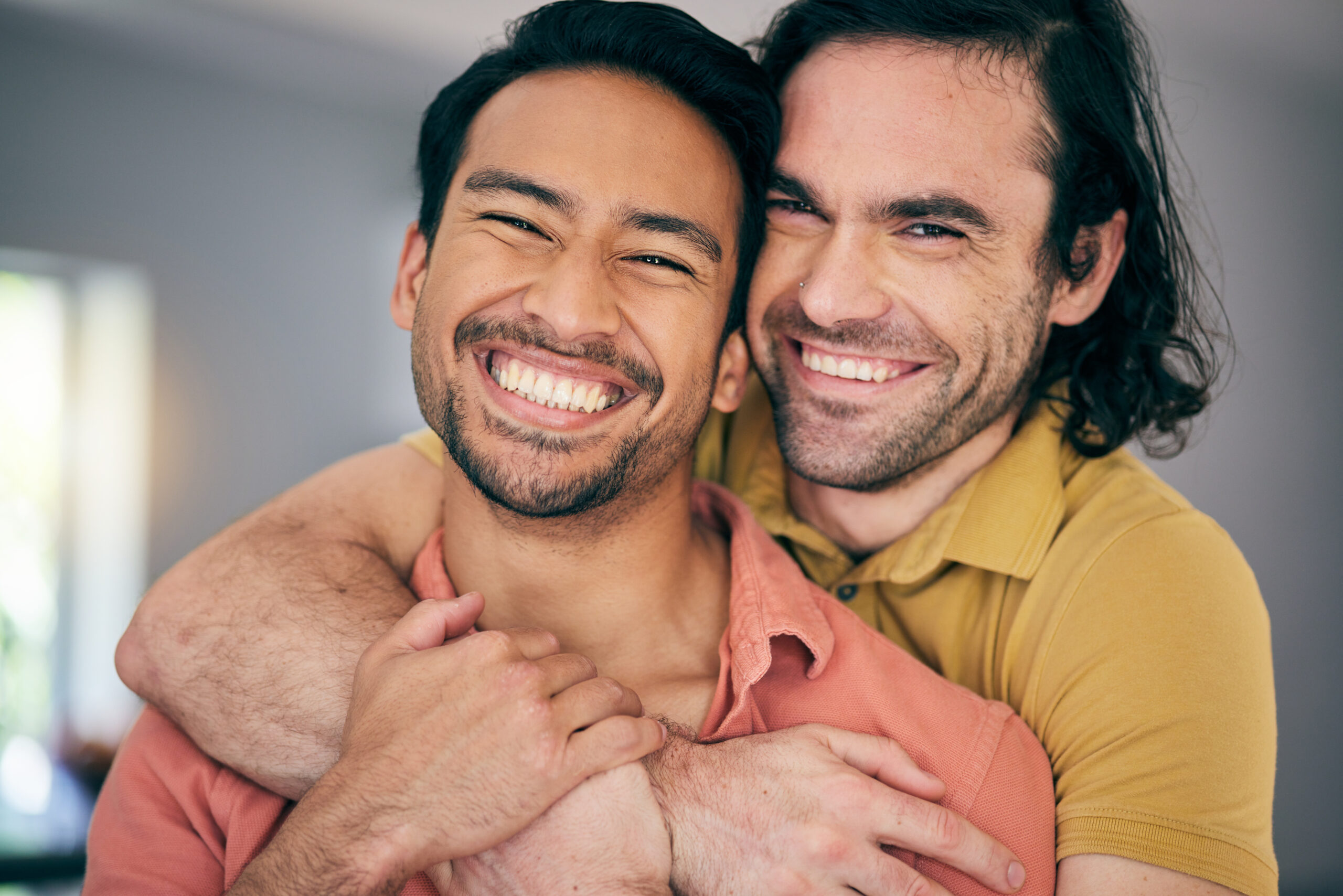 Two adult gay men sharing affectionate physical closeness at home