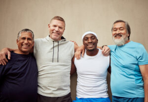 Happy men, exercise group and portrait in city on wall background outdoor. Smile, fitness and mature male friends with happiness for workout, community wellness or support of healthy sports diversity.